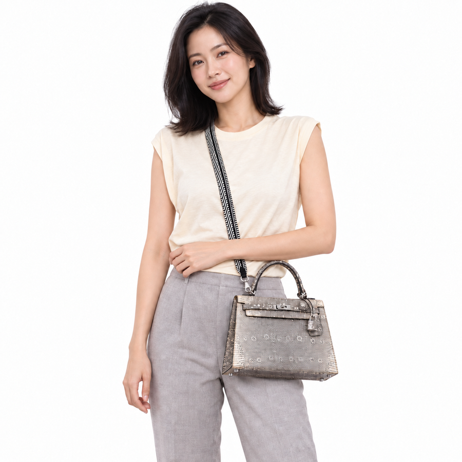 Hermès Kelly 25 Sellier Ombre Lizard Palladium Hardware shown on a model in a white studio.
