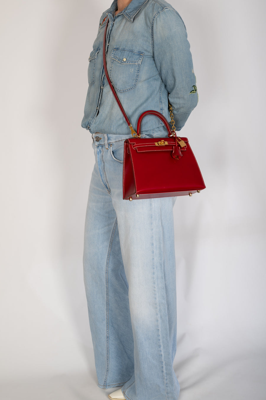 Hermès Kelly 25 Sellier Rouge Piment Box Calf Gold Hardware, worn crossbody on the shoulder strap