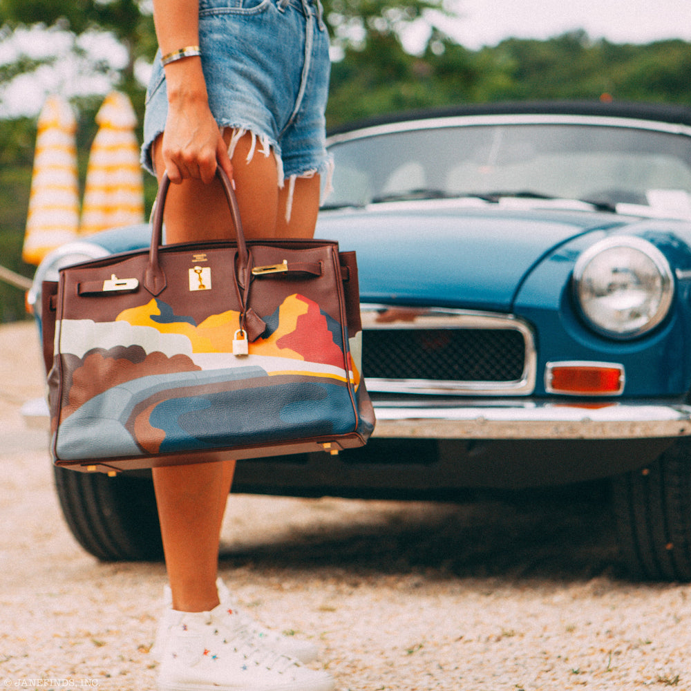 A multicolored Hermès Birkin carried beside a vintage car, from the JaneFinds photographic archive