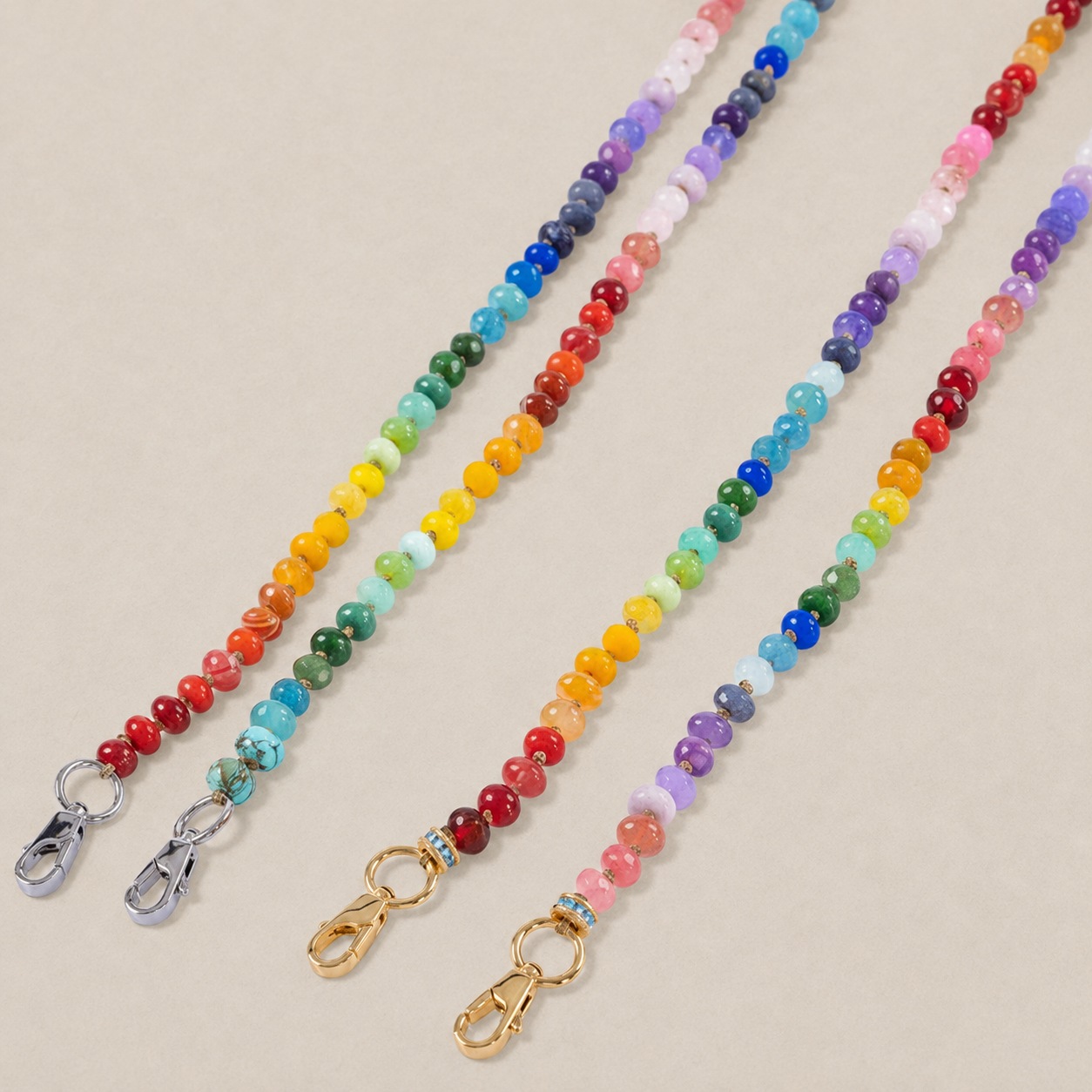 JaneFinds beaded semi-precious stone crossbody chains in four colorways on a warm neutral studio background