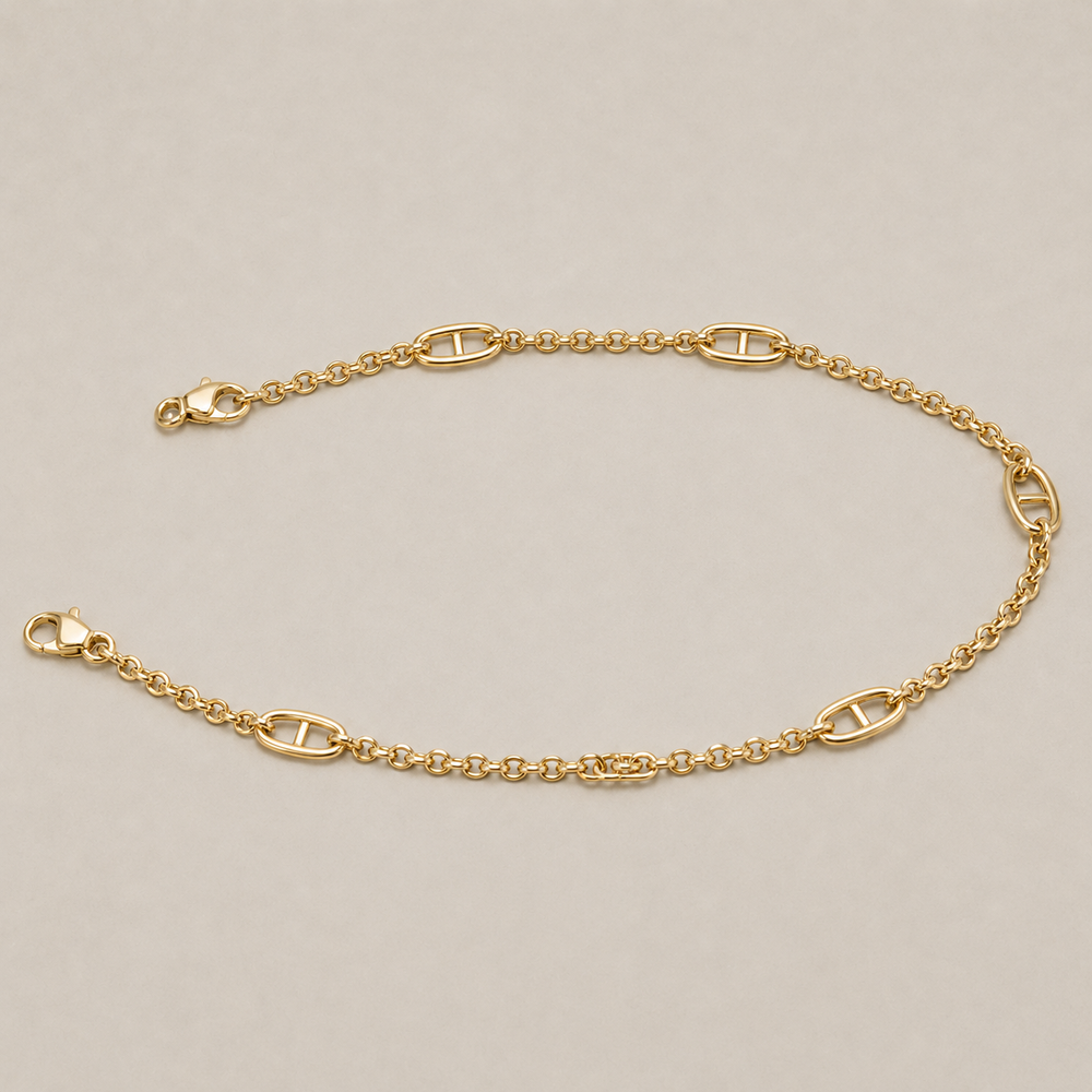 JaneFinds gold Mariner crossbody chain arranged in an oval on a warm neutral studio background