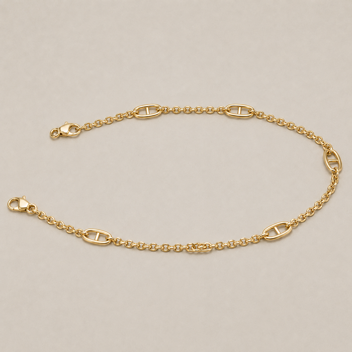 JaneFinds gold Mariner crossbody chain arranged in an oval on a warm neutral studio background