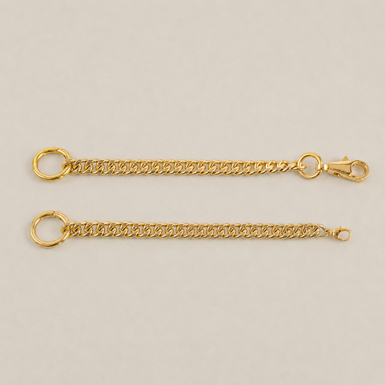 JaneFinds gold Extender Chains with standard and small clip options on a warm neutral studio background