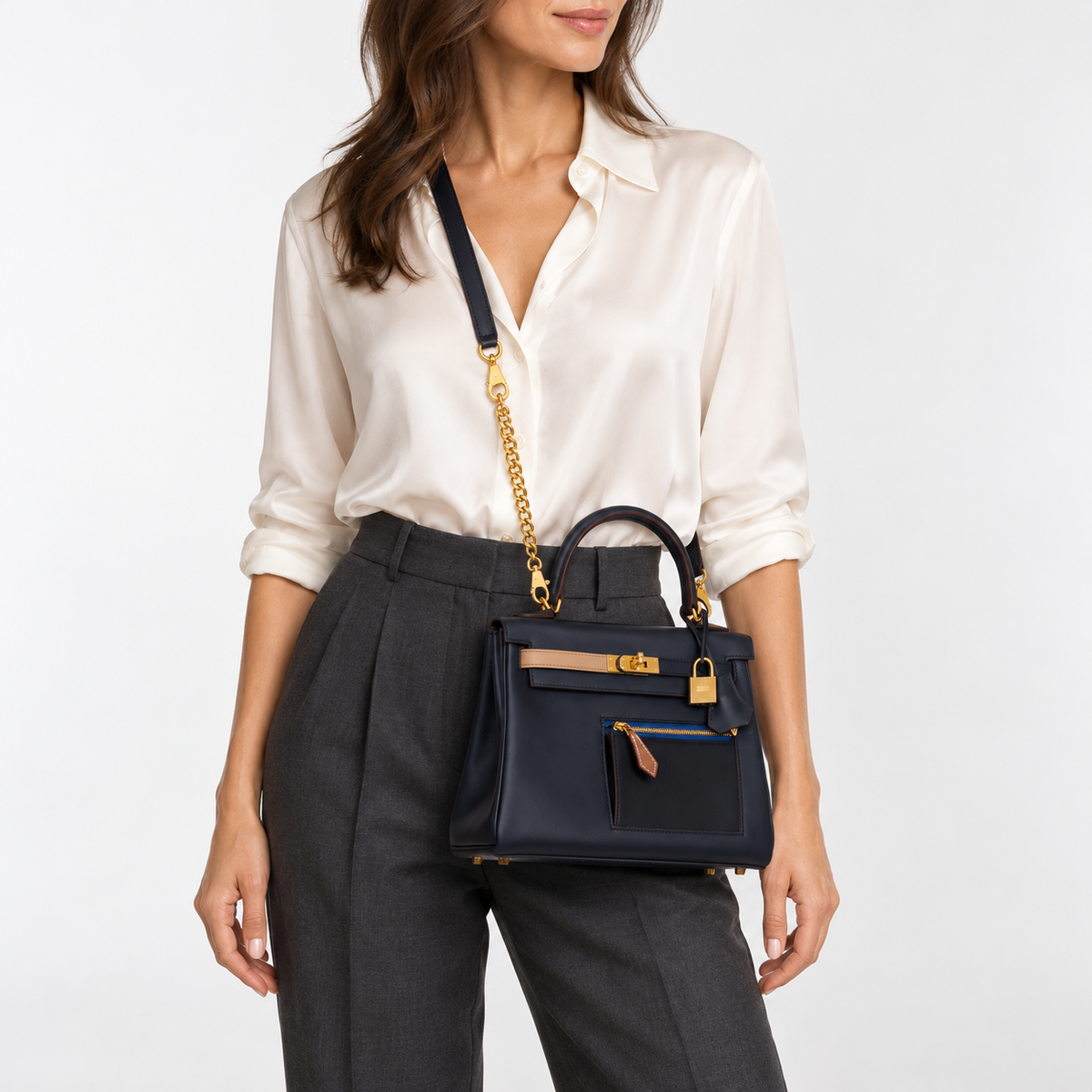 Hermès Colormatic Kelly 25 in Bleu Nuit on a human model, styled with its dark leather strap and a short gold Cuban extender.