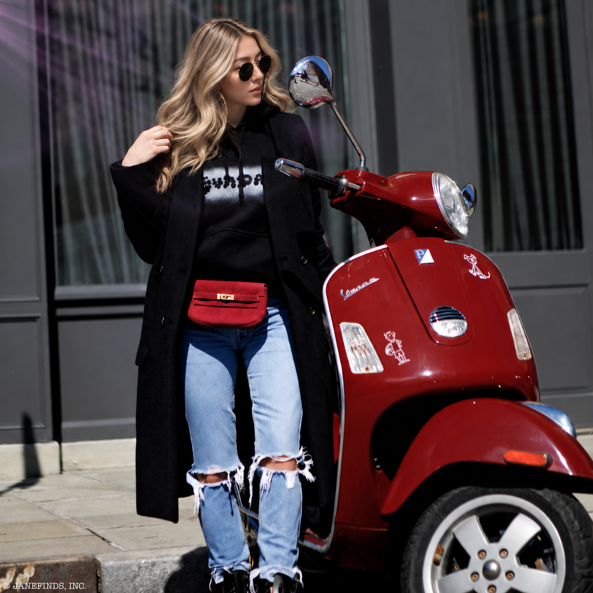 Hermès Mini Kelly Banana 20 Framboise Doblis suede belt bag with gold hardware, worn at the waist beside a red Vespa