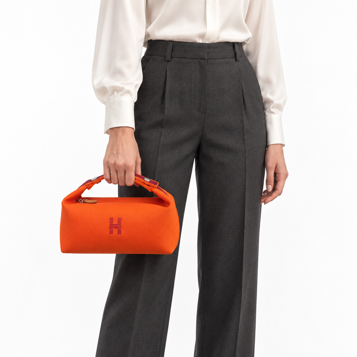 Hermès small Bride-a-Brac pouch in orange canvas with burgundy handle and embroidered H, front hand-carry studio model view