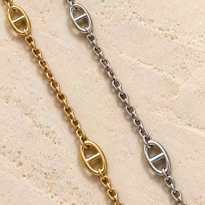 JaneFinds Mariner Crossbody Chain in Gold and Palladium on pale limestone, showing large oval anchor links separated by fine cable-link sections.