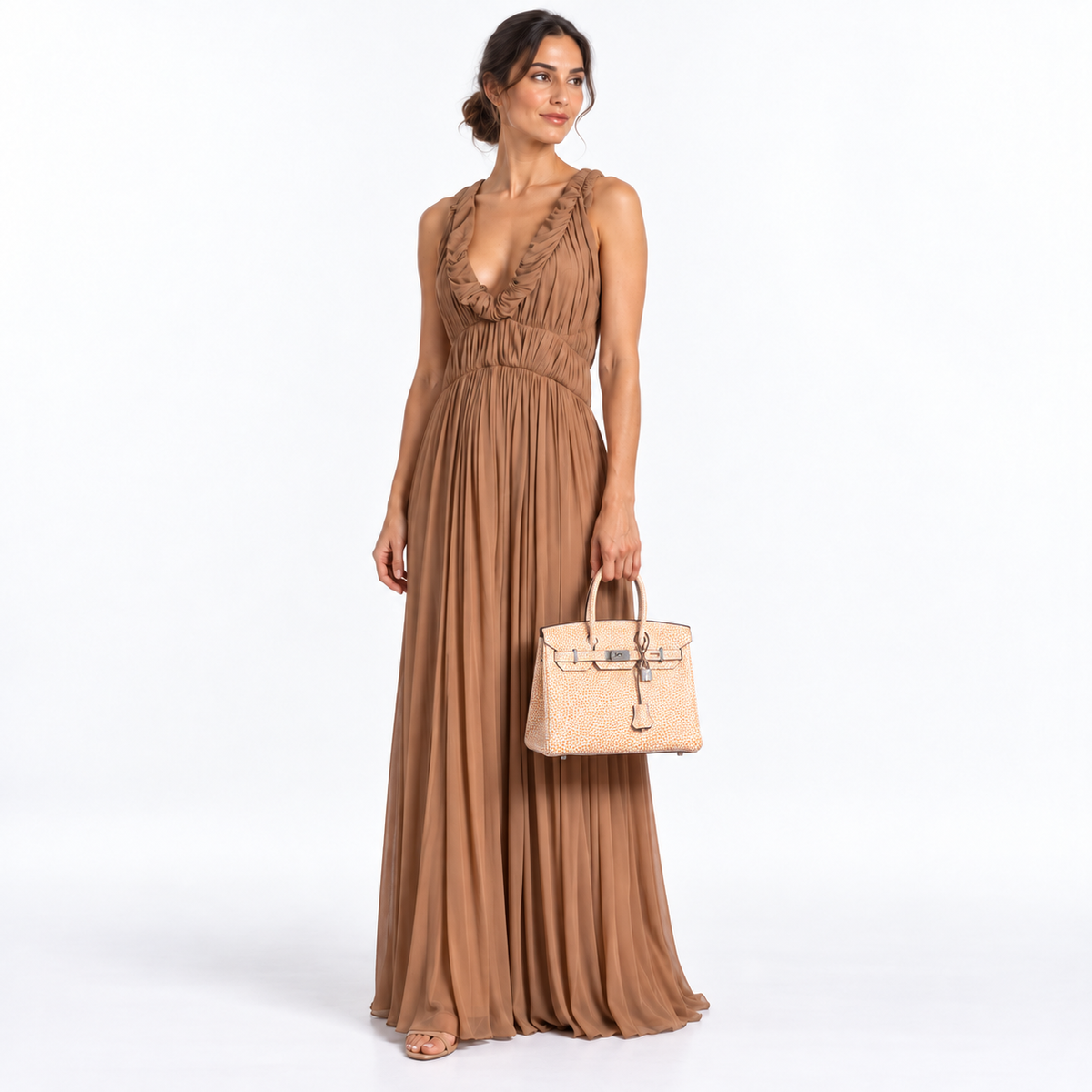 Hermès Dalmatian Birkin 30 Orange H Buffalo with palladium hardware, carried by a woman in a taupe gown against a white studio background