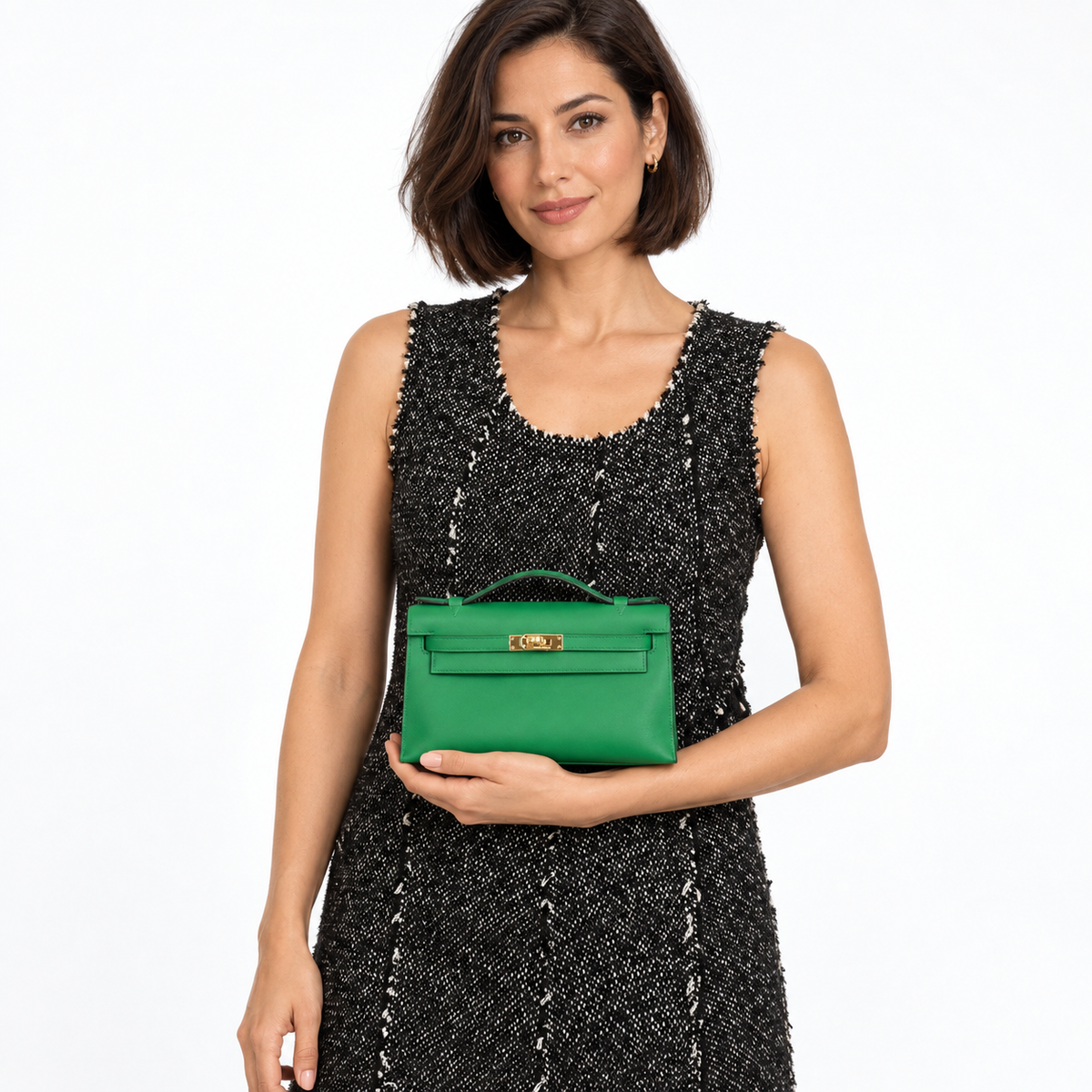 Hermès Kelly Mini Pochette Vert Vertigo Swift with gold hardware carried by a model