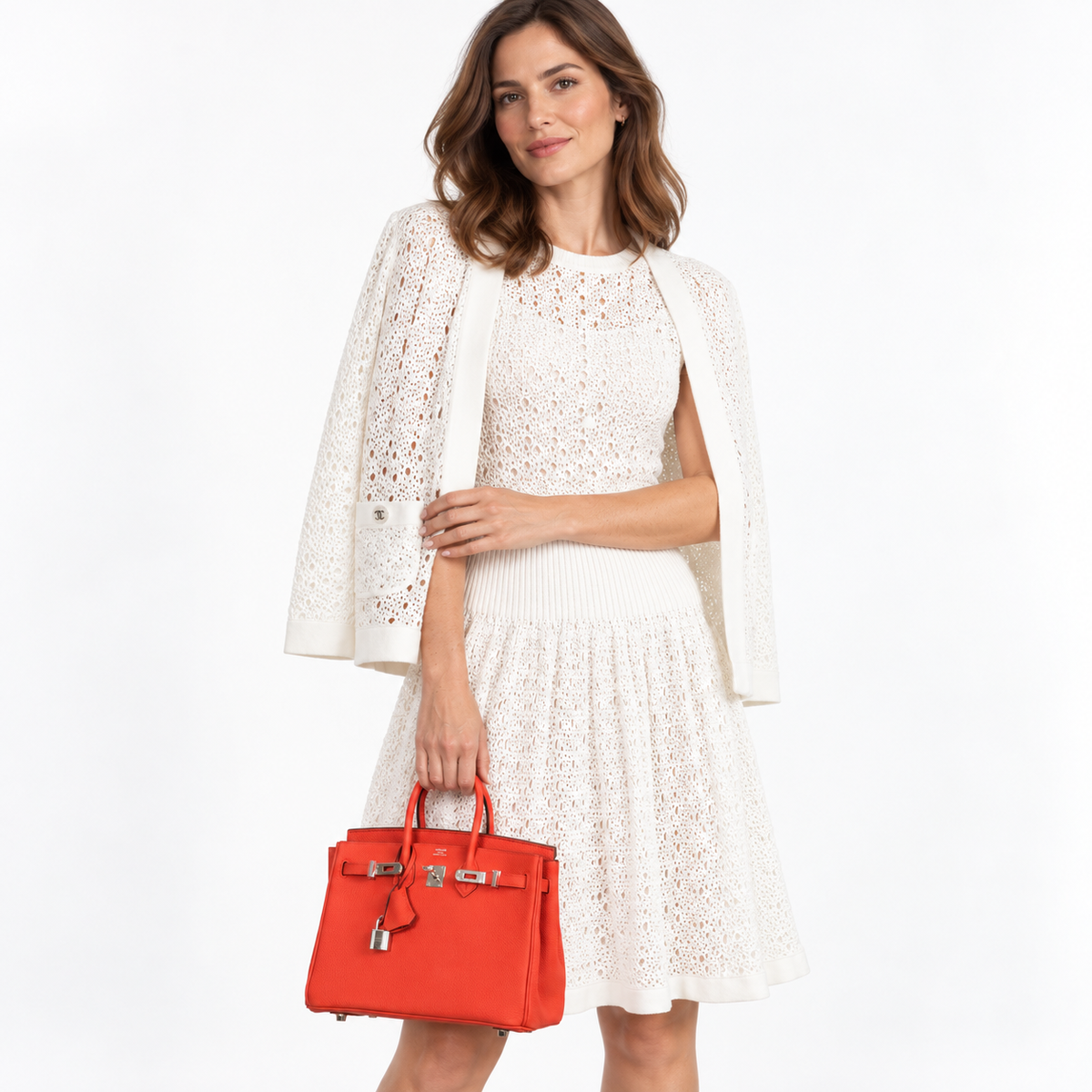 Hermès Birkin 25 Capucine Togo Palladium Hardware worn by a woman in a white studio