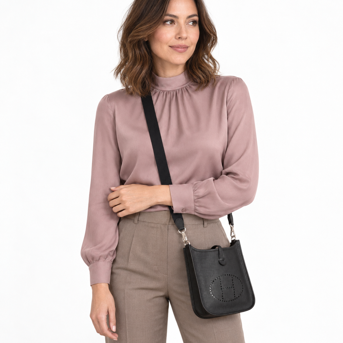 Hermès Evelyne TPM Black Epsom Palladium Hardware worn by a woman in a white studio