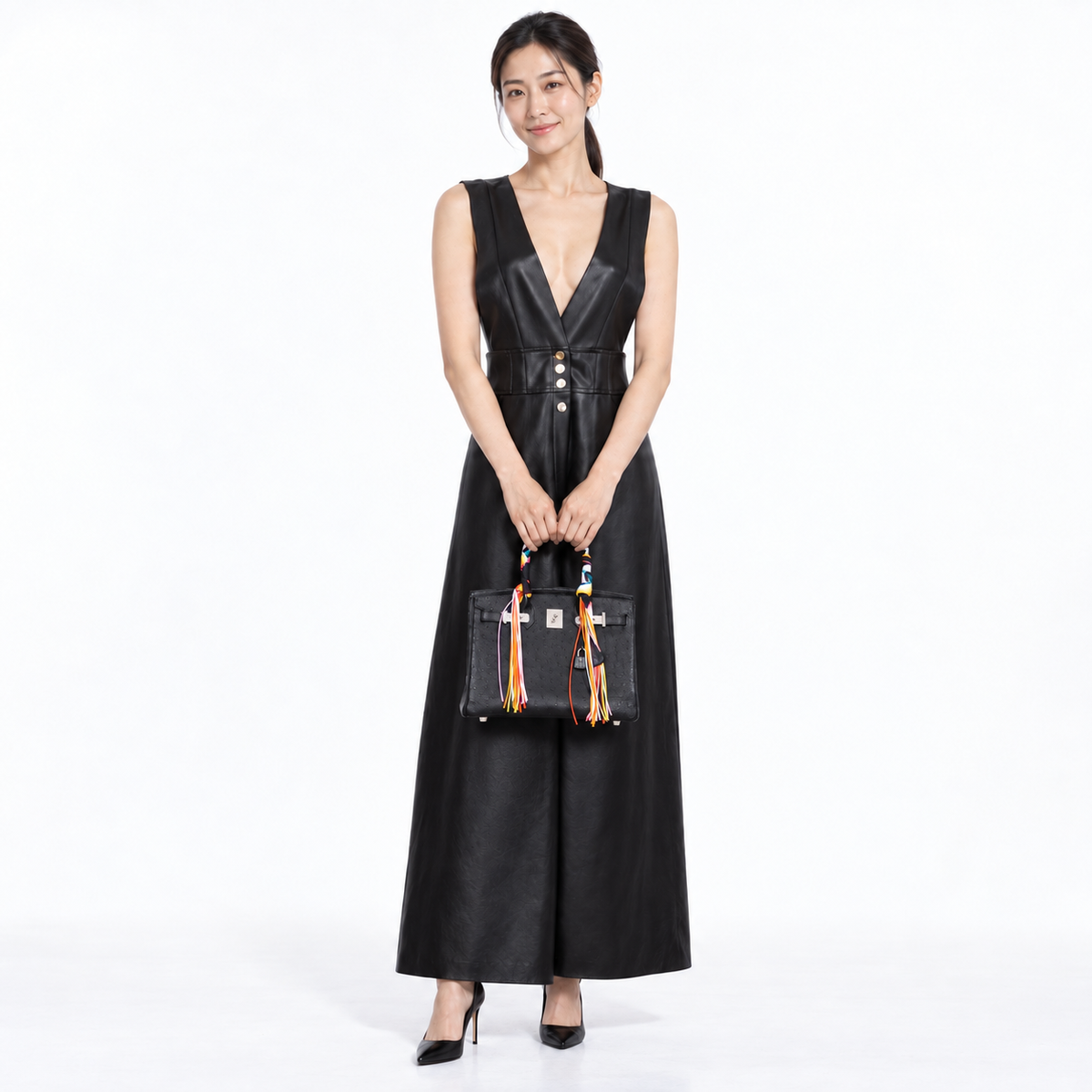 Hermès Birkin 30 Black Ostrich with palladium hardware and colorful handle scarf, carried by a woman in a black leather dress in a white studio