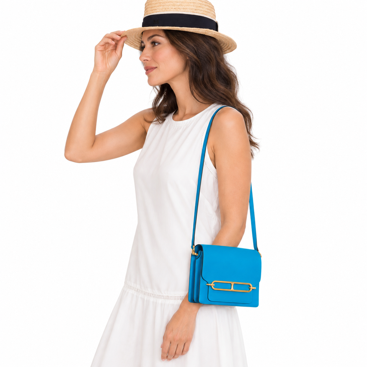 Hermès Roulis Mini Evercolor Blue Zanzibar Gold Hardware carried by a human model on a white studio background.