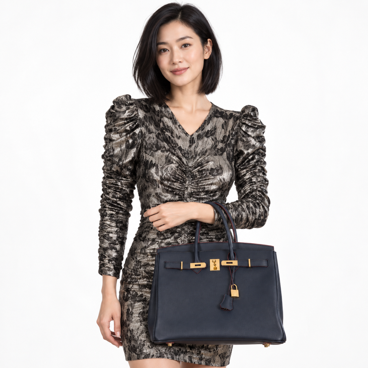 Hermès Birkin 35 Blue Indigo Contour Rouge H Epsom gold hardware carried on forearm by a model in a white studio