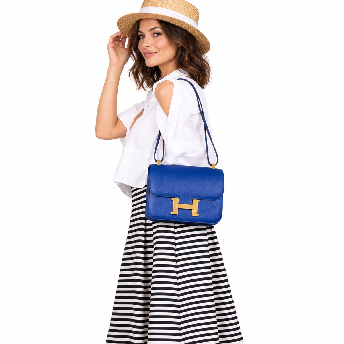 Hermès Constance 24 Blue Electrique Epsom Gold Hardware shown on a model in a white studio.