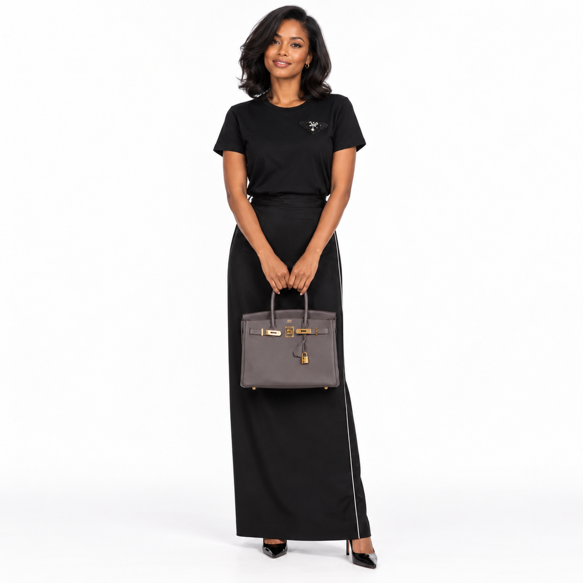 Hermès Birkin 30 Etain Togo with Gold Hardware shown on a model in a white studio.