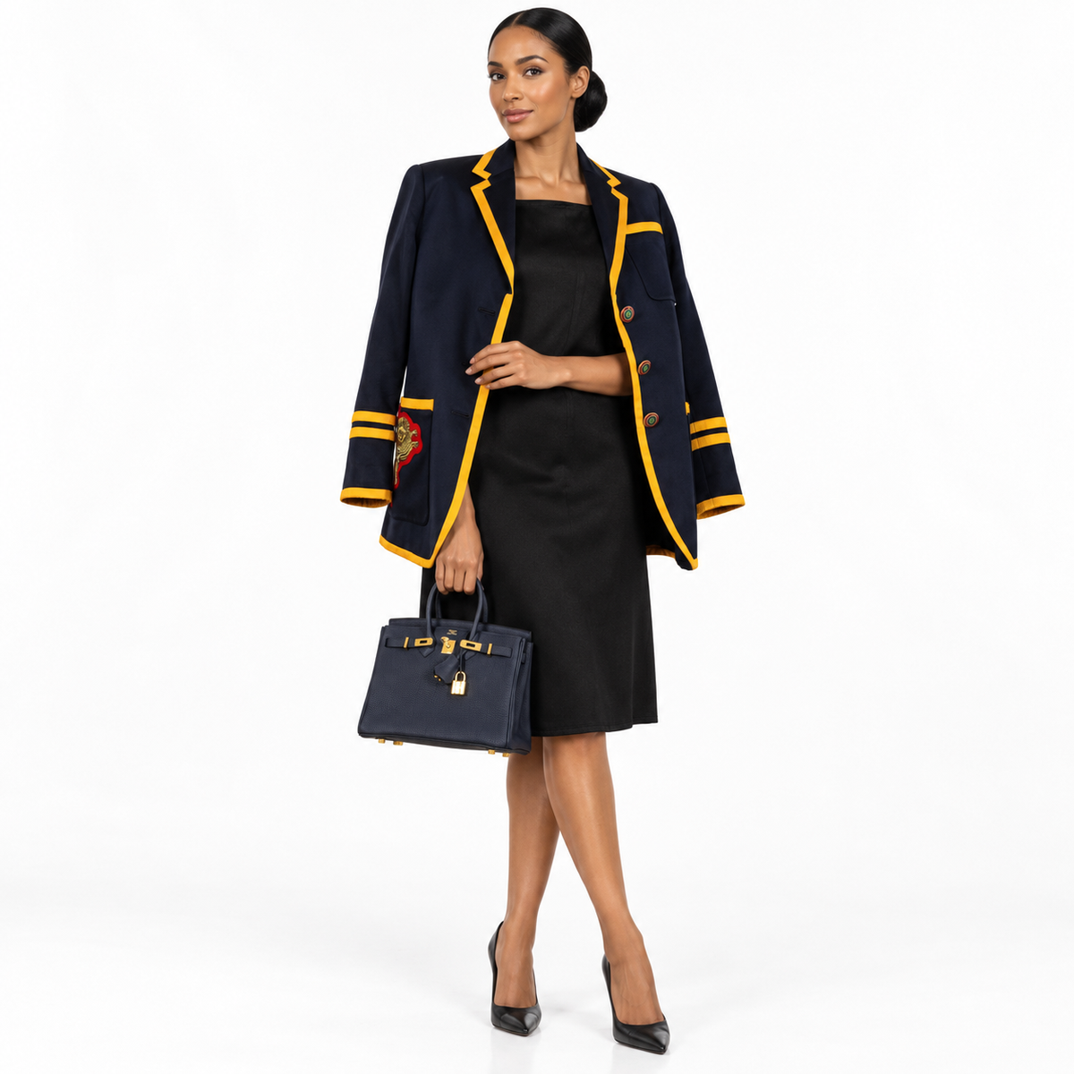 Hermès Birkin 25 Bleu Nuit Togo gold hardware carried by a model in a white studio