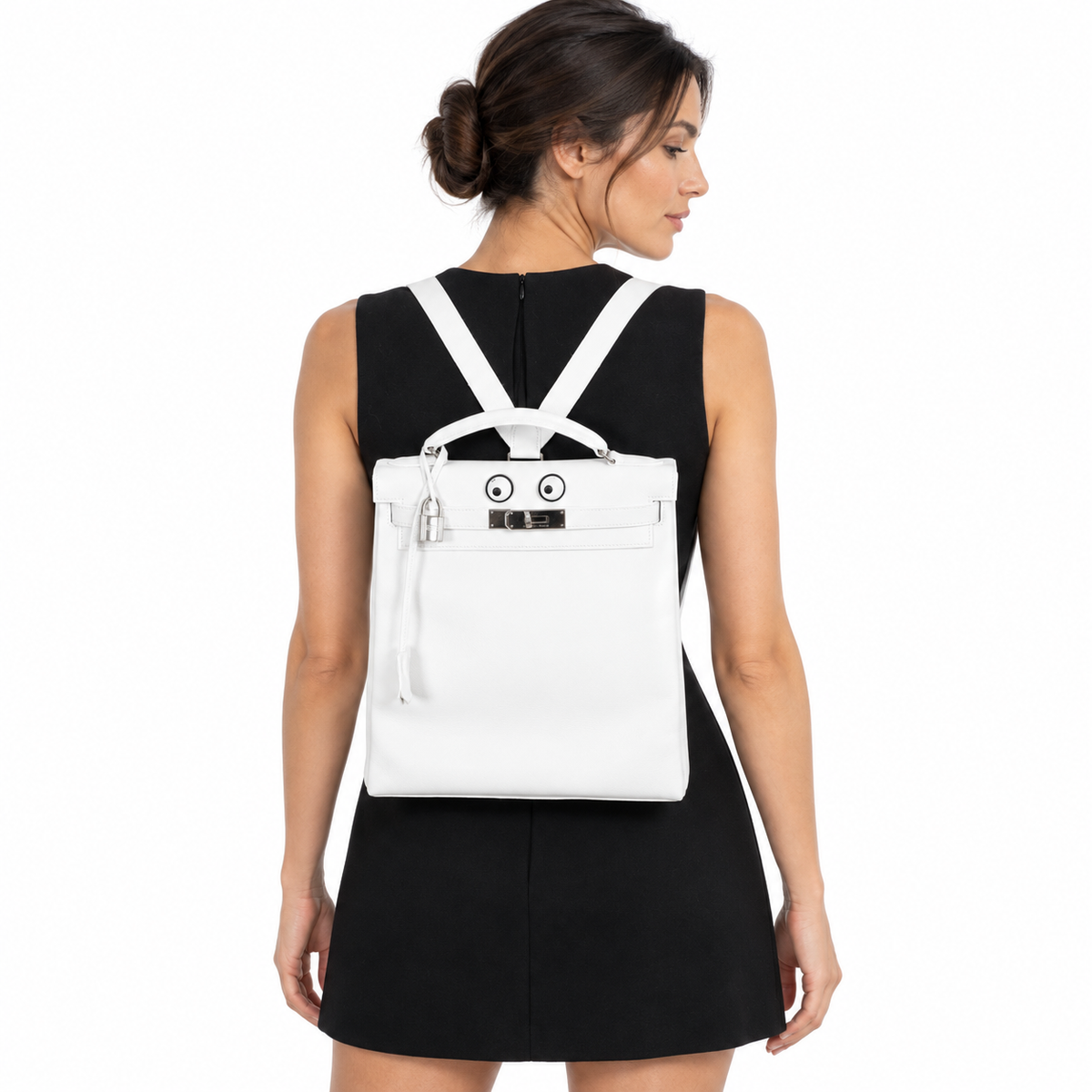 Hermès Kelly 27 Ado Backpack White Graine Palladium Hardware worn by an adult model in a white studio