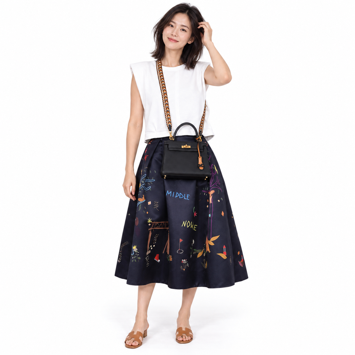 Hermès Kelly 25 Retourne Black Togo Gold Hardware - 2020, Y shown on a model in a white studio.