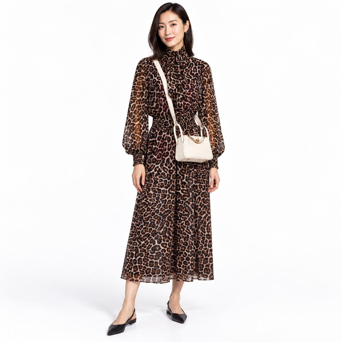 Hermès Mini Lindy 20 Nata Clemence with gold hardware worn crossbody by a woman in a leopard print dress in a white studio