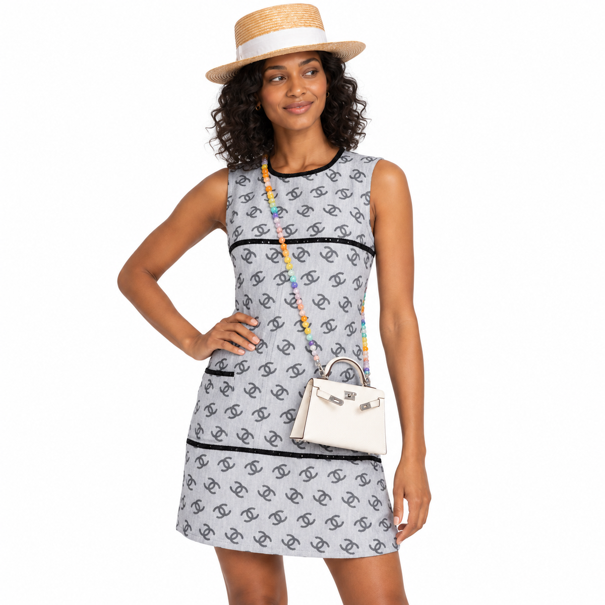 Hermès Mini Kelly 20 Nata Epsom styled with a colorful bead chain and open sangles on a woman in a gray dress
