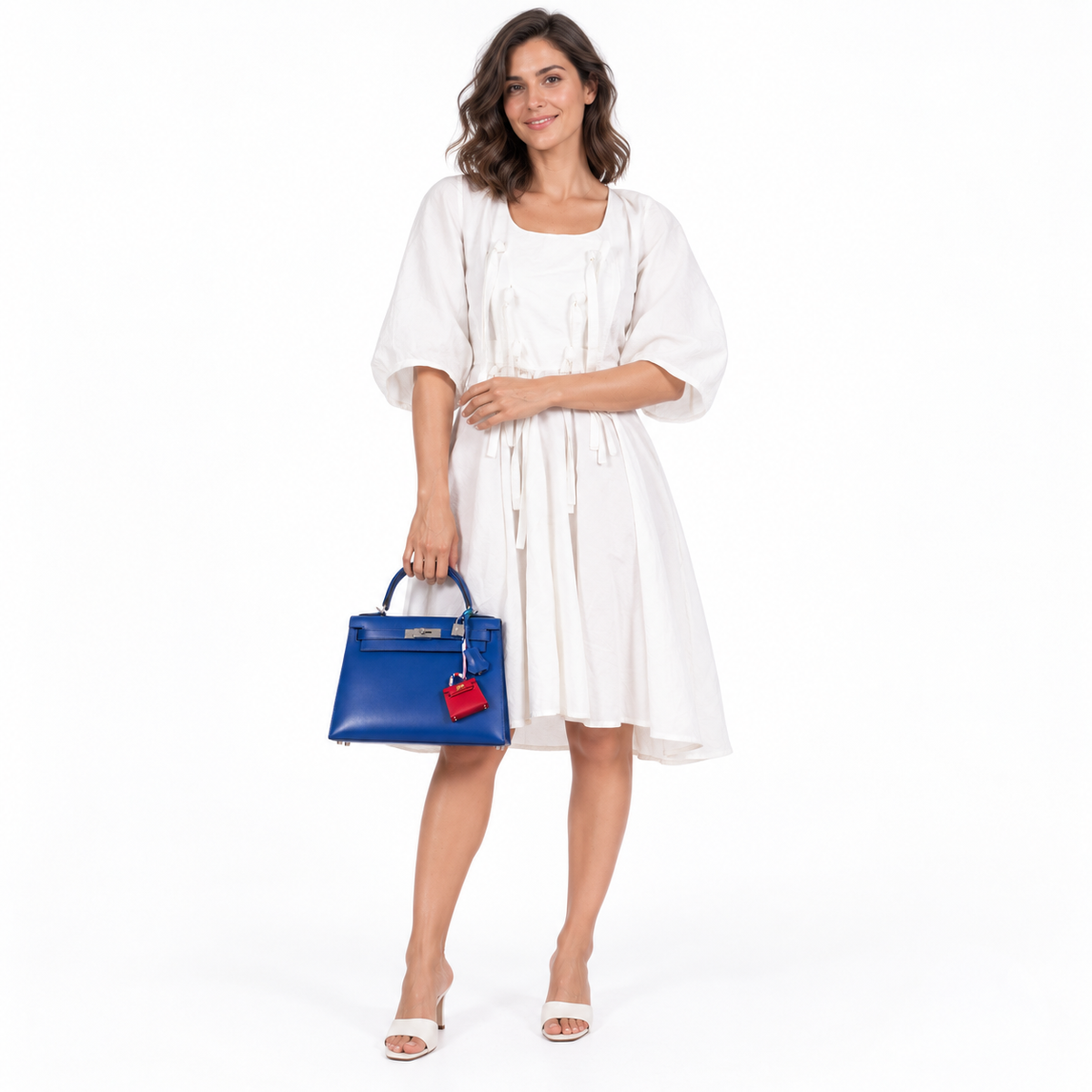 Hermès Kelly 28 Sellier Blue Electric Tadelakt leather Palladium Hardware shown on a model in a white studio.