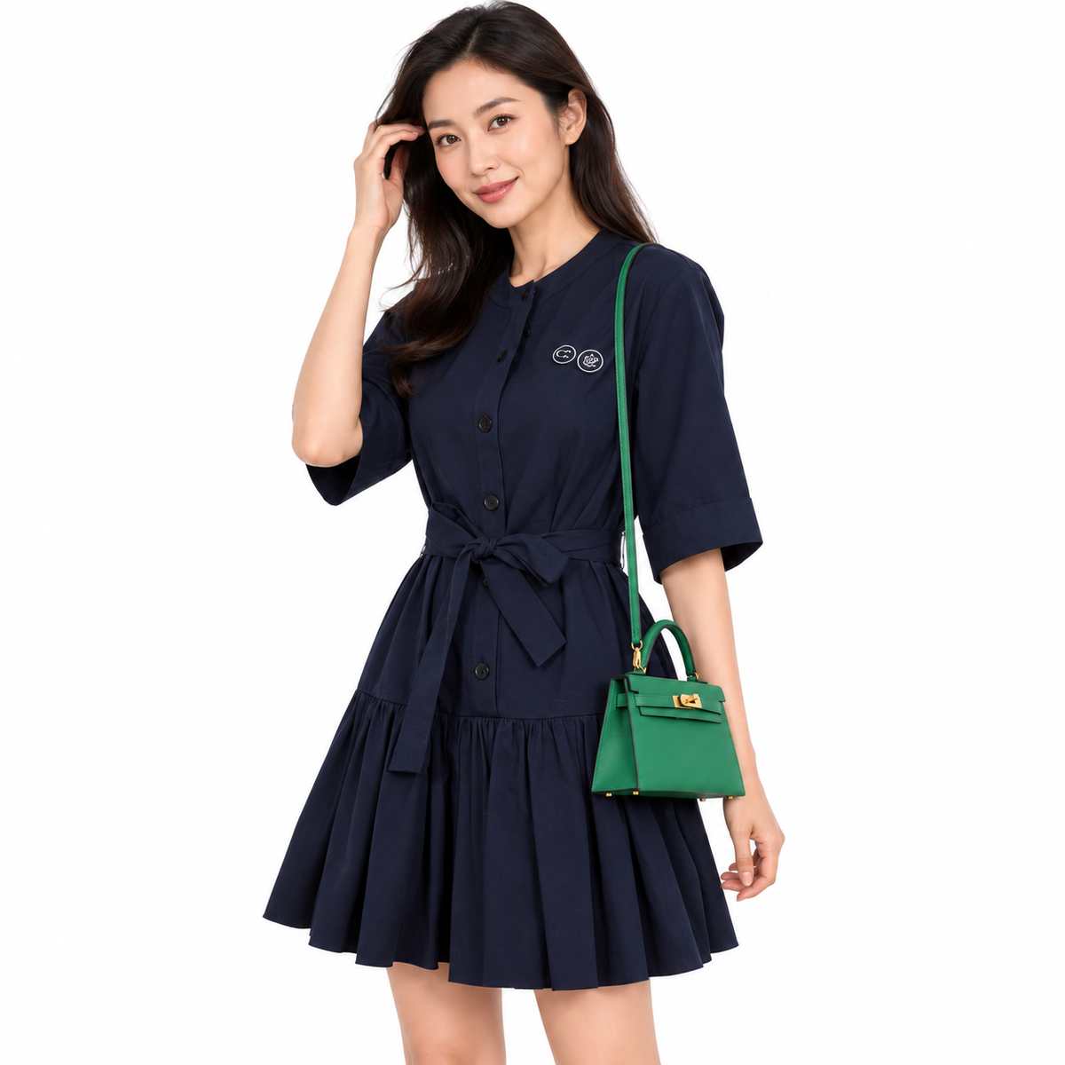 Hermès Kelly 20 Mini II Cactus Epsom with gold hardware worn on the shoulder by an adult model in a white studio