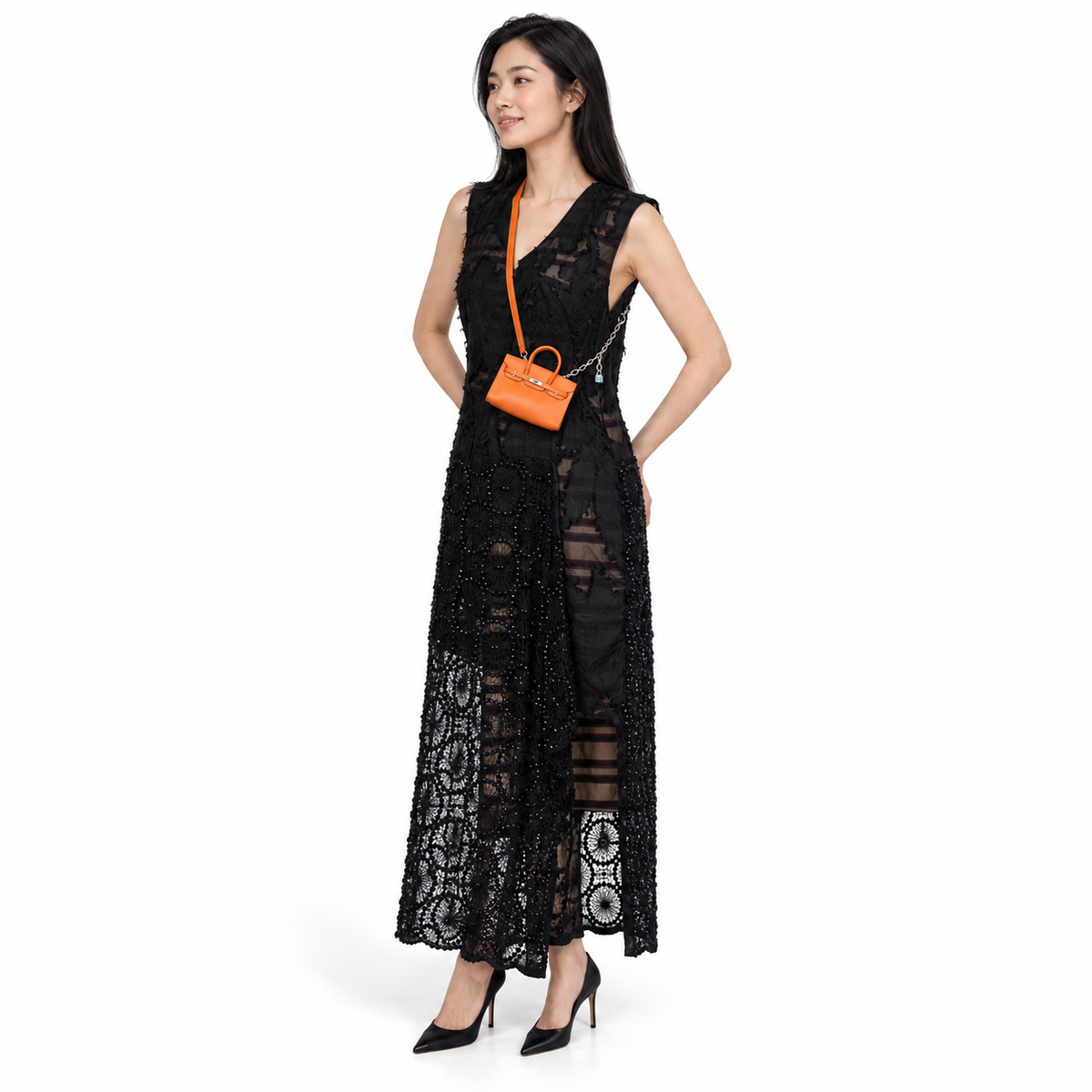 Hermès Birkin 15 Micro Orange Swift with Palladium Hardware worn by a model in a white studio