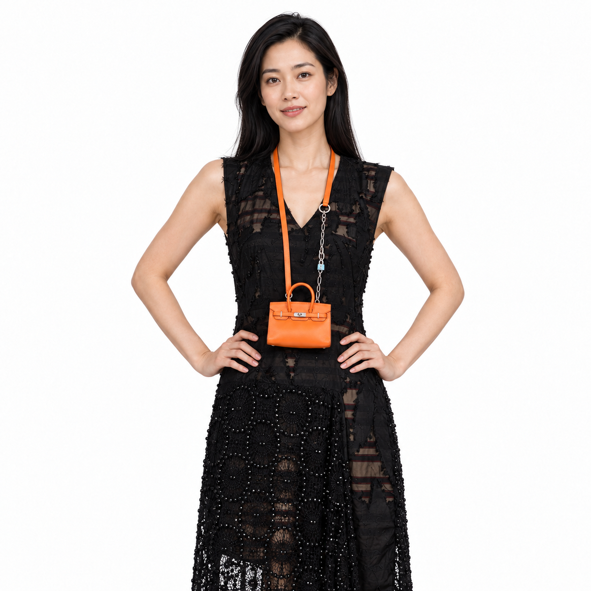 Hermès Birkin 15 Micro Orange Swift with Palladium Hardware worn by a model in a white studio