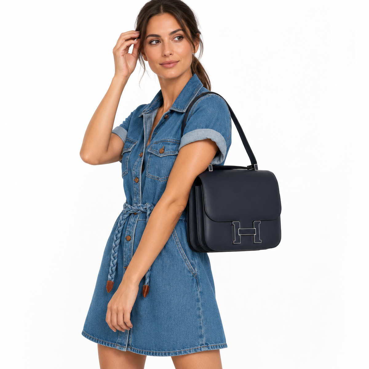 Hermès Constance 29 Cartable Bleu Obscur Veau Sombrero Palladium Hardware carried by a model in a white studio