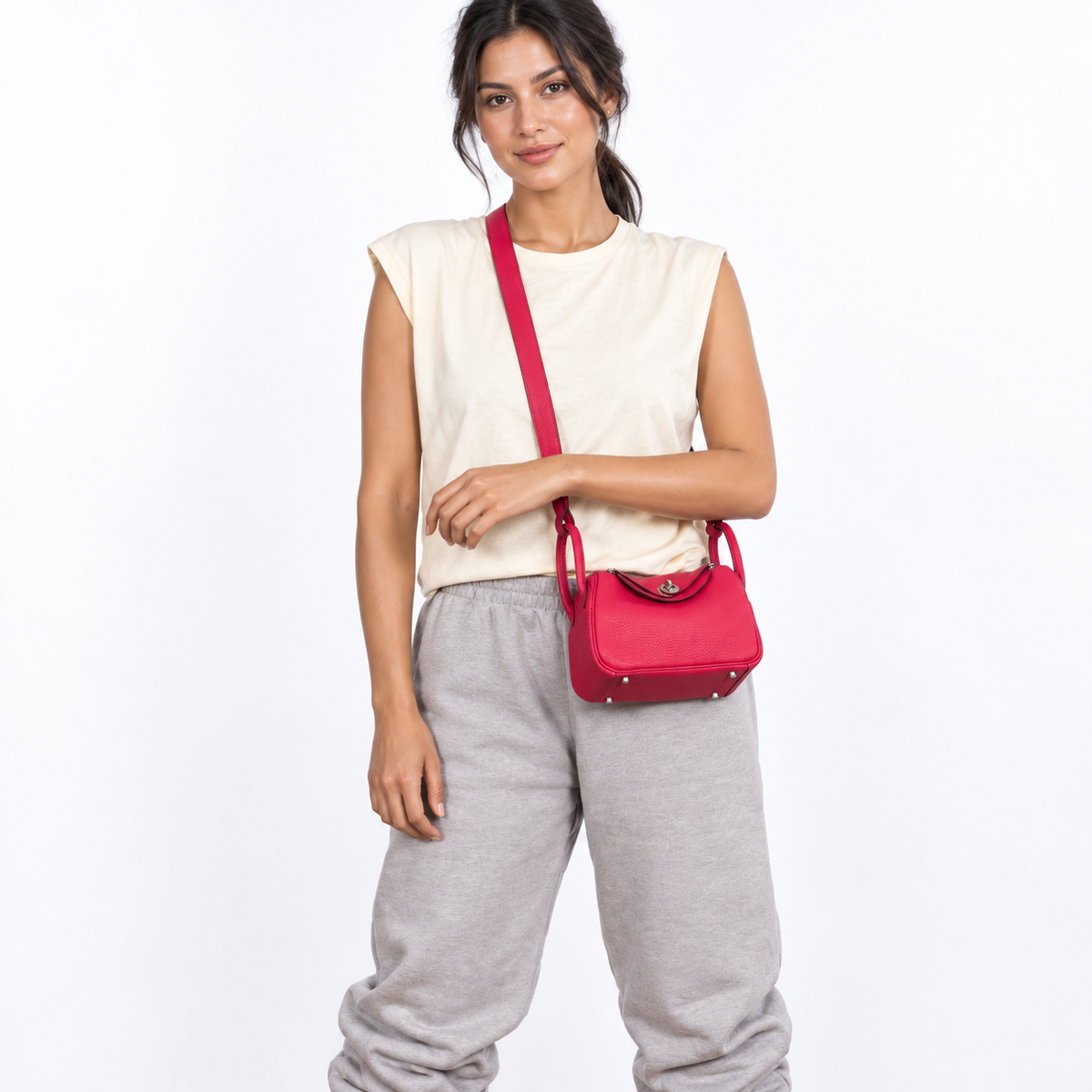 Hermès Mini Lindy 20 Rose Extreme Clemence with palladium hardware worn crossbody by an adult model in a white studio