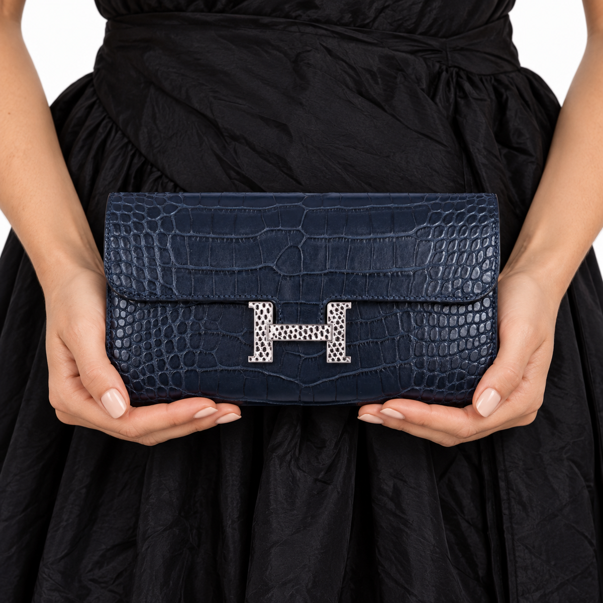Hermès Constance Long Wallet Matte Blue Night Alligator Lizard 'H' Closure on an adult model in a white studio — carry detail