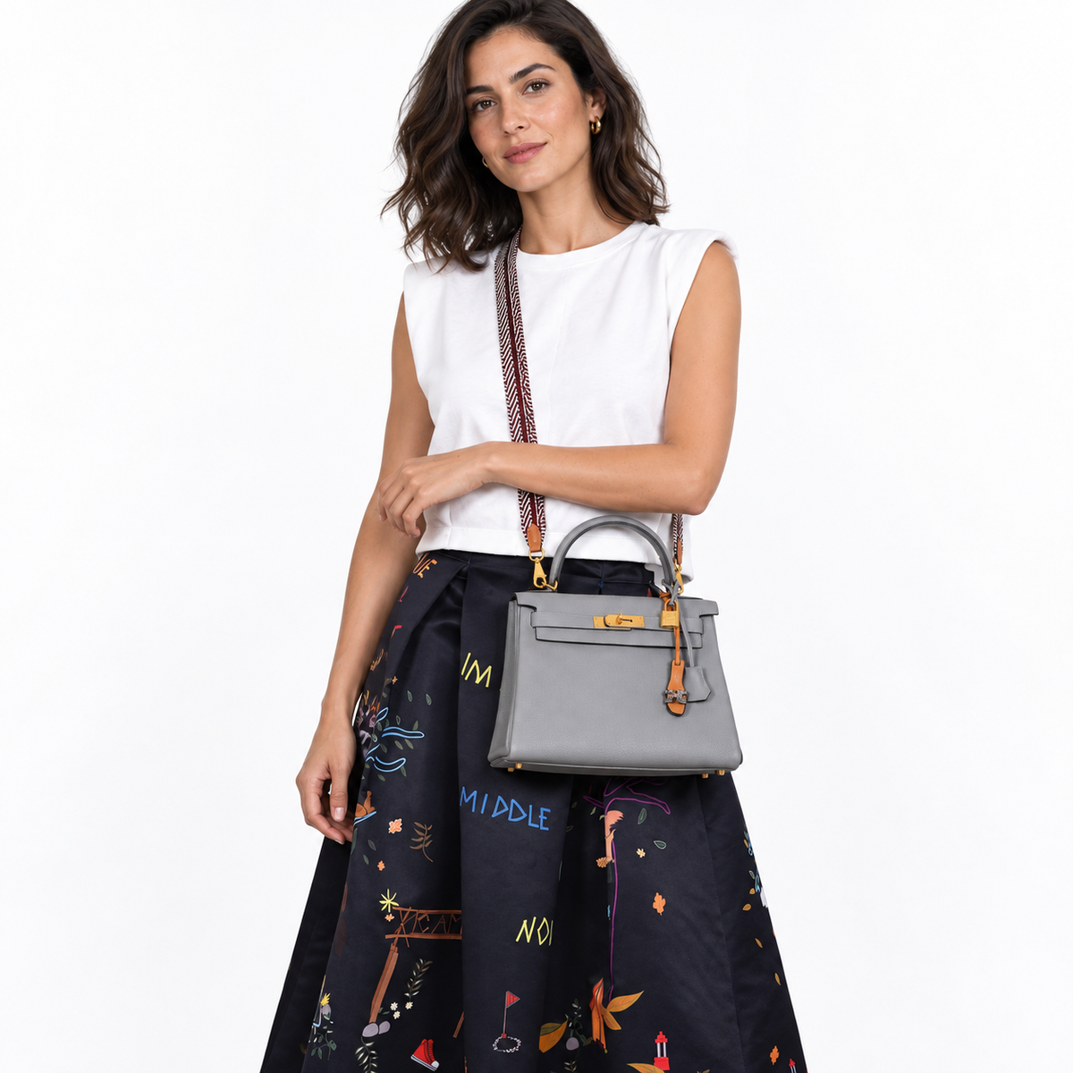 Hermès Kelly 28 Gris Mouette with patterned shoulder strap worn by a model on white