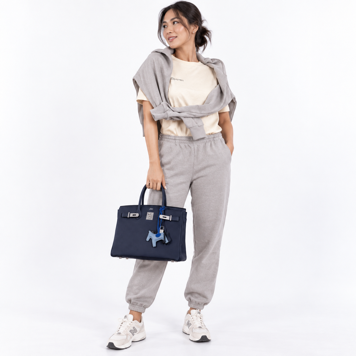 Hermès Birkin 30 Blue Nuit Togo Leather with Palladium Hardware shown on a model carrying the bag in a white studio
