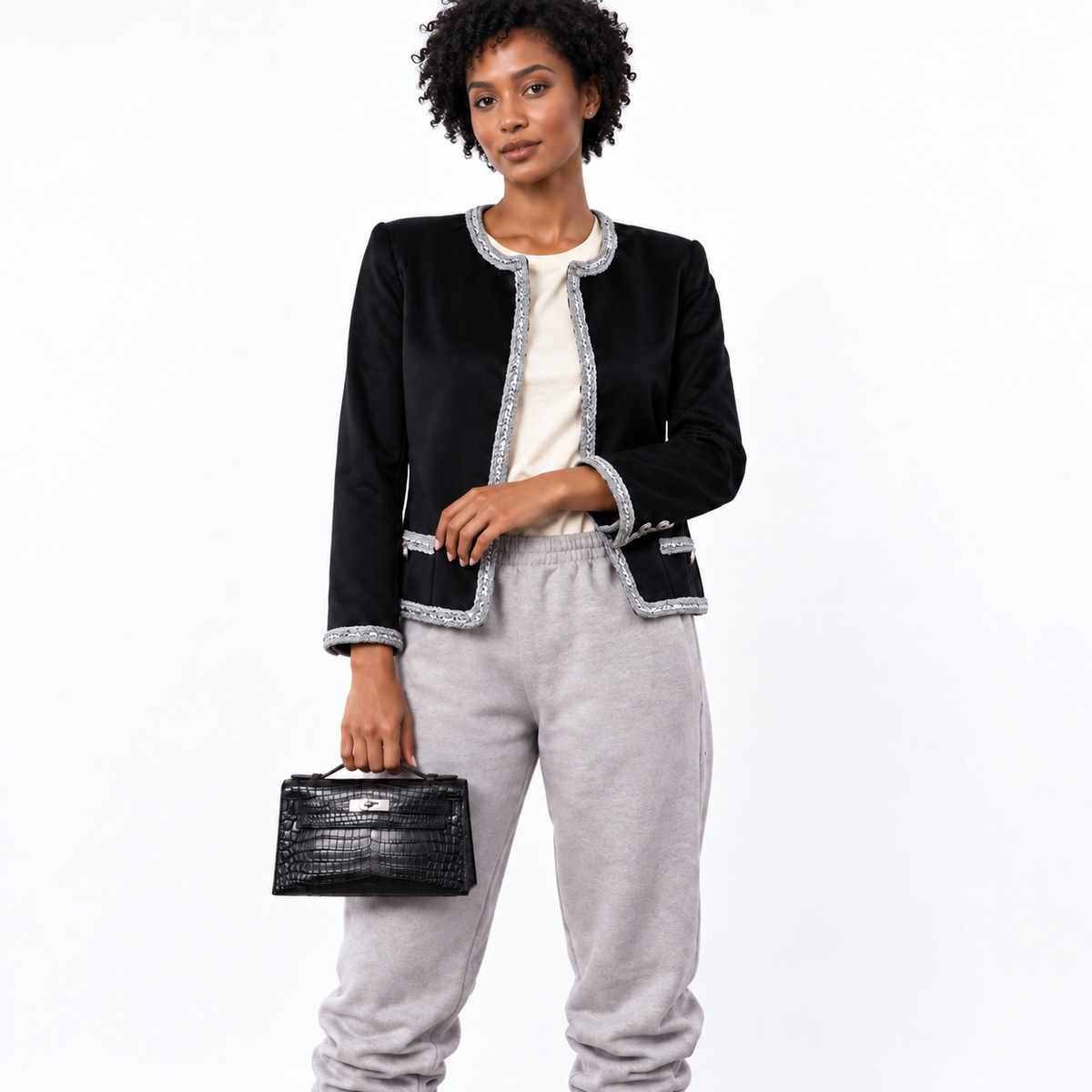 Hermès Kelly Pochette black Niloticus crocodile palladium hardware carried by a model on white