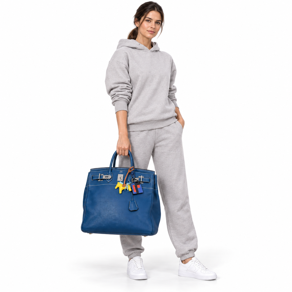 Hermès HAC Birkin 40 Bleu Thalassa Togo palladium hardware and yellow Rodeo charm carried by a model in a white studio