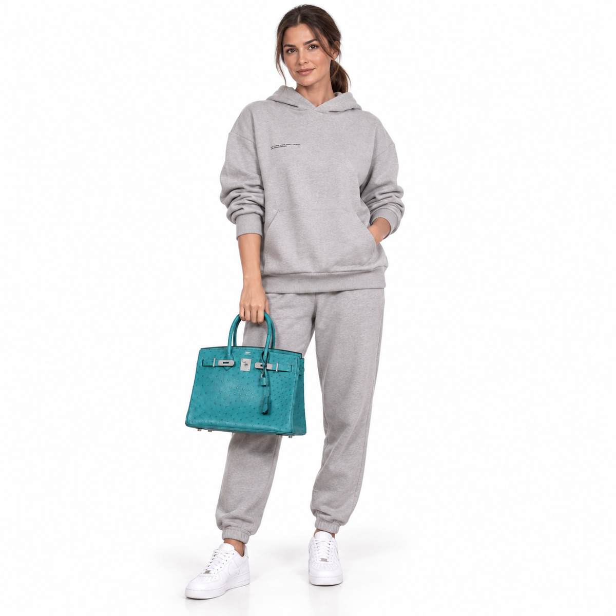 Hermès Birkin 30 Vert Verone ostrich palladium hardware carried by a model in a white studio