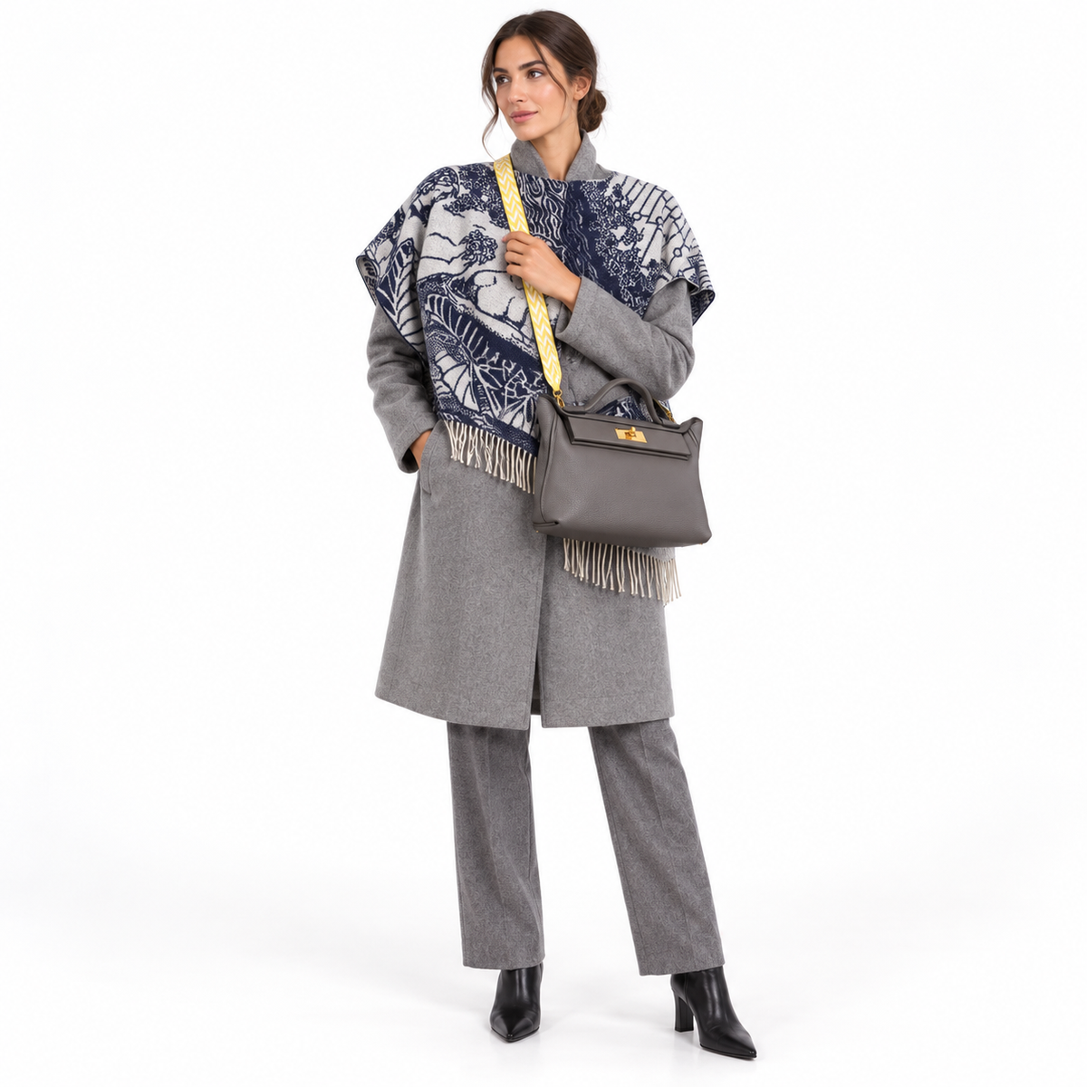 Hermès 24/24 29 Etain Togo and Swift gold hardware with yellow chevron strap worn crossbody by a model in a white studio