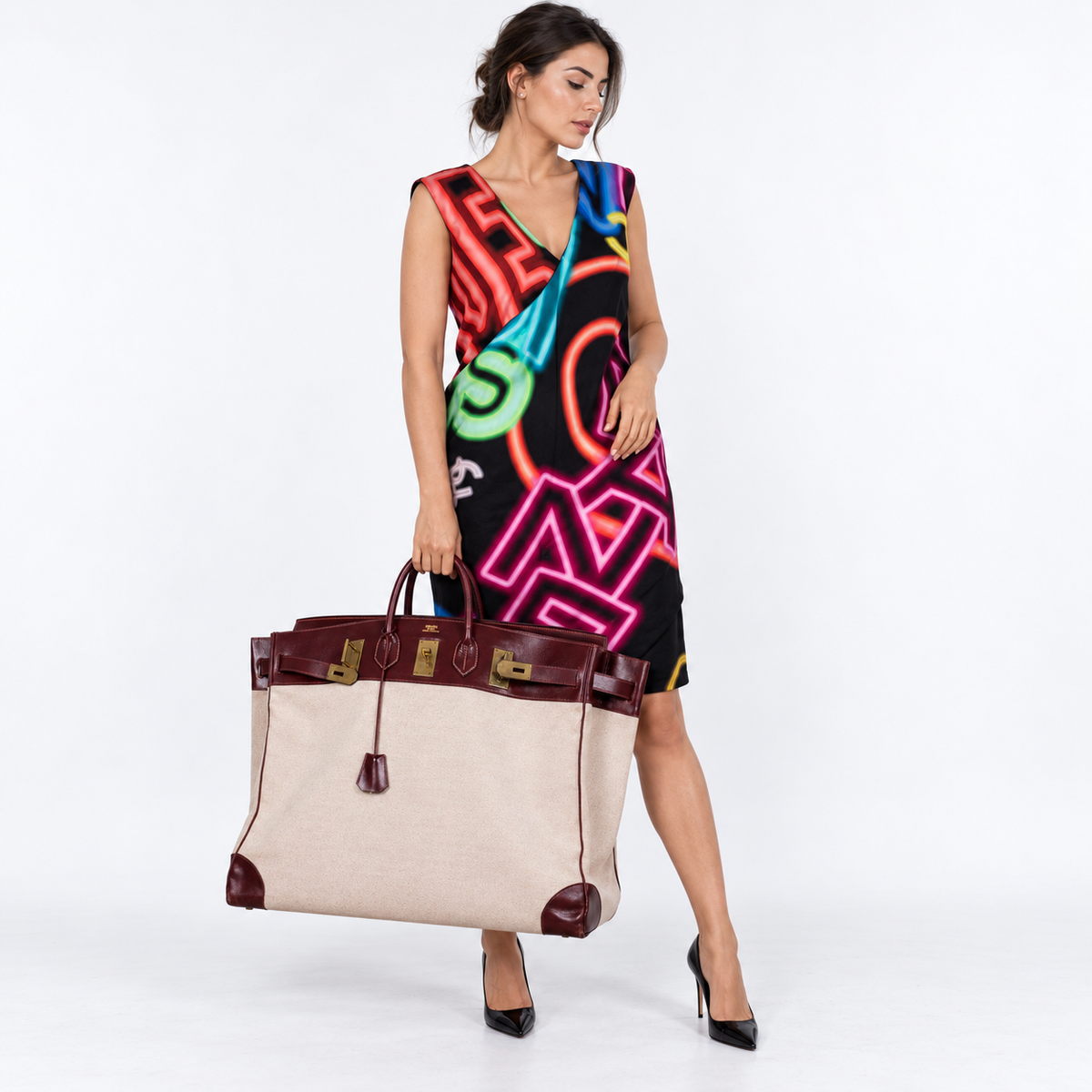 Hermès HAC Birkin 55 natural Toile and Rouge H Box leather gold hardware carried by a model in a white studio