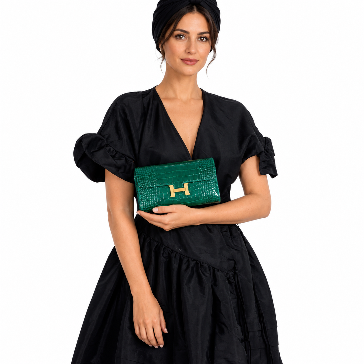 Hermès Constance Long Wallet Polished Emerald Alligator Gold Plated 'H' Closure shown on an adult model in a white studio