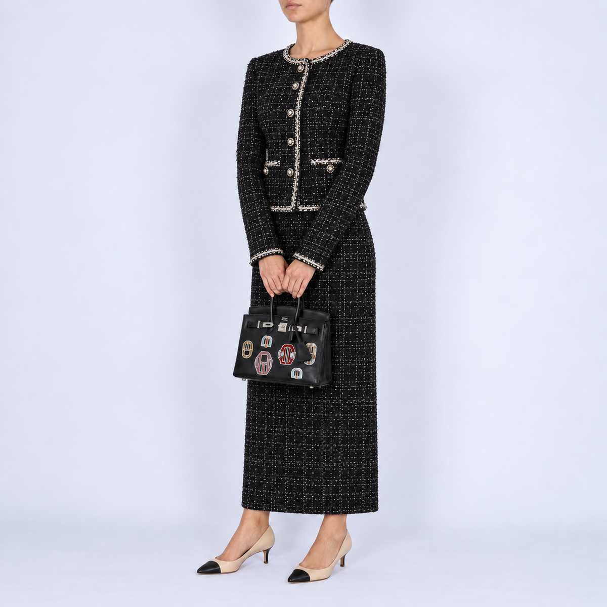 Hermès Birkin 20 Bouclerie Moderne Casaque Noir with palladium hardware, carried with a refined black tweed ensemble.