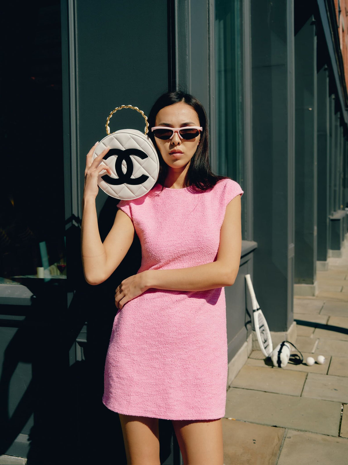 Chanel Round CC Vanity White and Black Patent Leather Gold Hardware, held up beside the face by a model