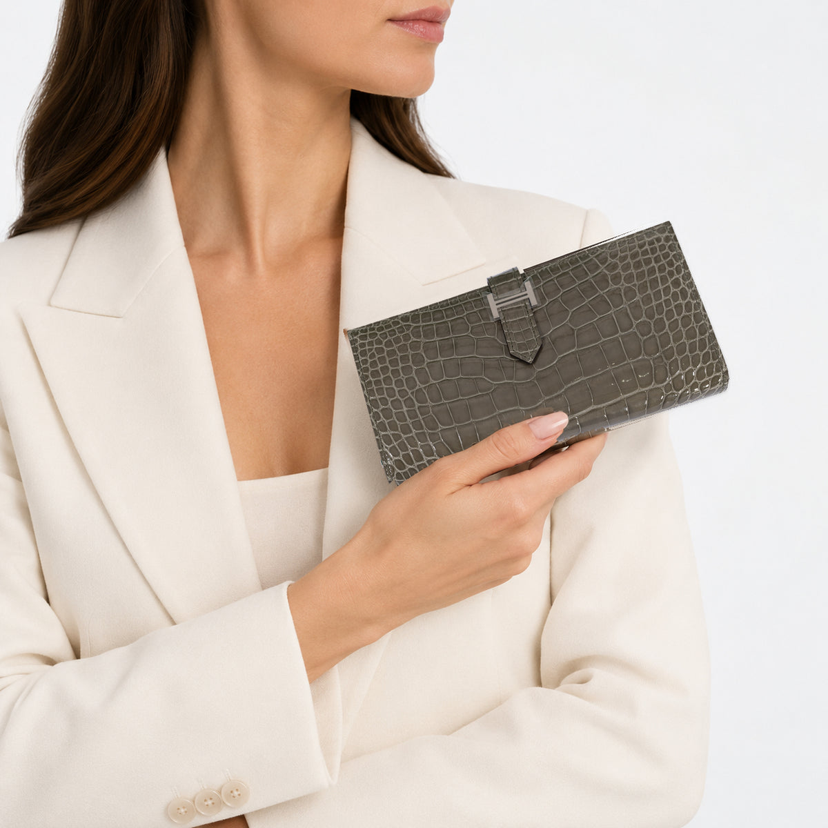 Hermès Béarn Soufflet Gris Ciment Shiny Alligator Palladium Hardware, held by a model wearing an ivory jacket.