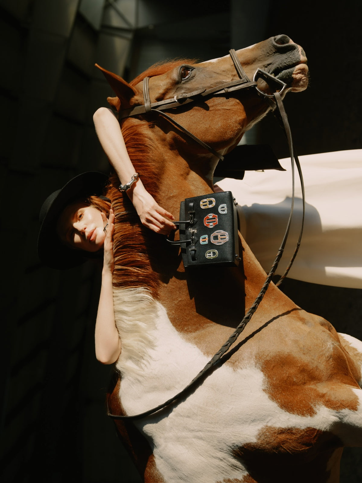 Hermès Birkin 20 Sellier Bouclerie Moderne Casaque Noir Chèvre Chamkila Palladium Hardware, held by a model reclining on a horse