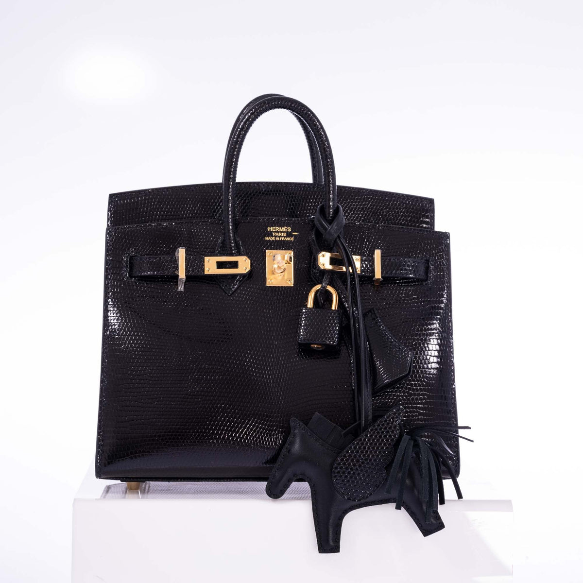 Hermès Birkin 20 Sellier Noir Shiny Varanus Niloticus Lizard Gold Hardware, angled view, styled with a Rodeo charm, not included