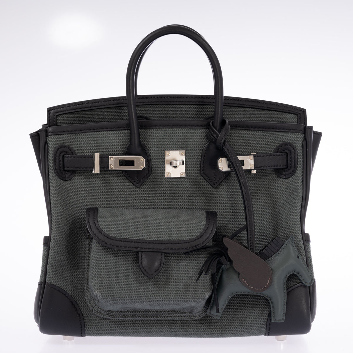 Hermès Birkin 25 Cargo Vert Mangrove Toile Goéland and Noir Swift Palladium Hardware, open with the flap folded back and straps undone, styled with a Rodeo Pegasus charm, sold separately