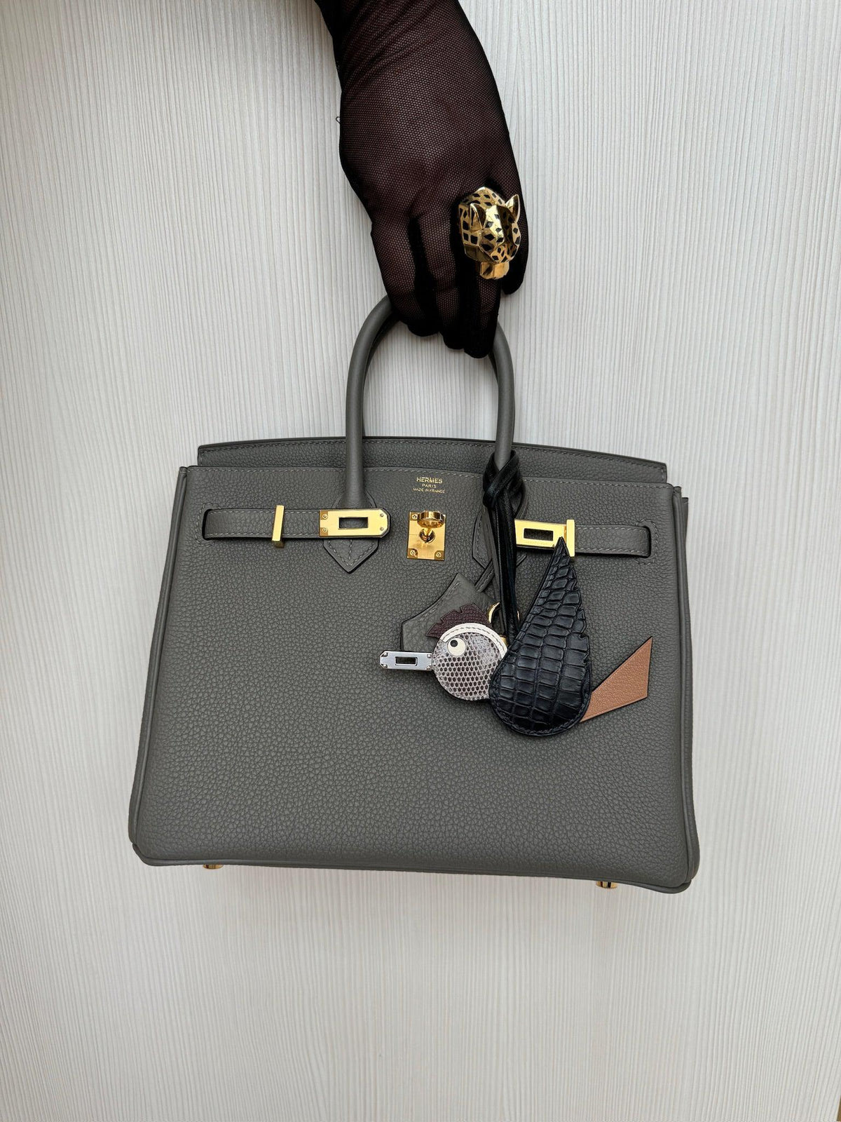 Hermès Birkin 25 Étain Togo Gold Hardware held by hand, styled with charms sold separately