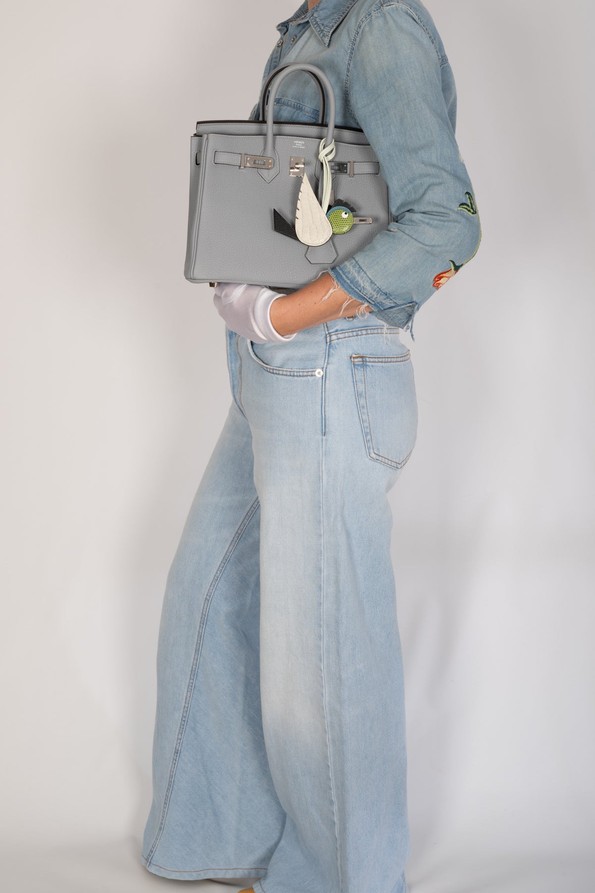 Hermès Birkin 25 Gris Meyer Togo Palladium Hardware, carried under the arm with the flap open, styled with a bird charm, sold separately