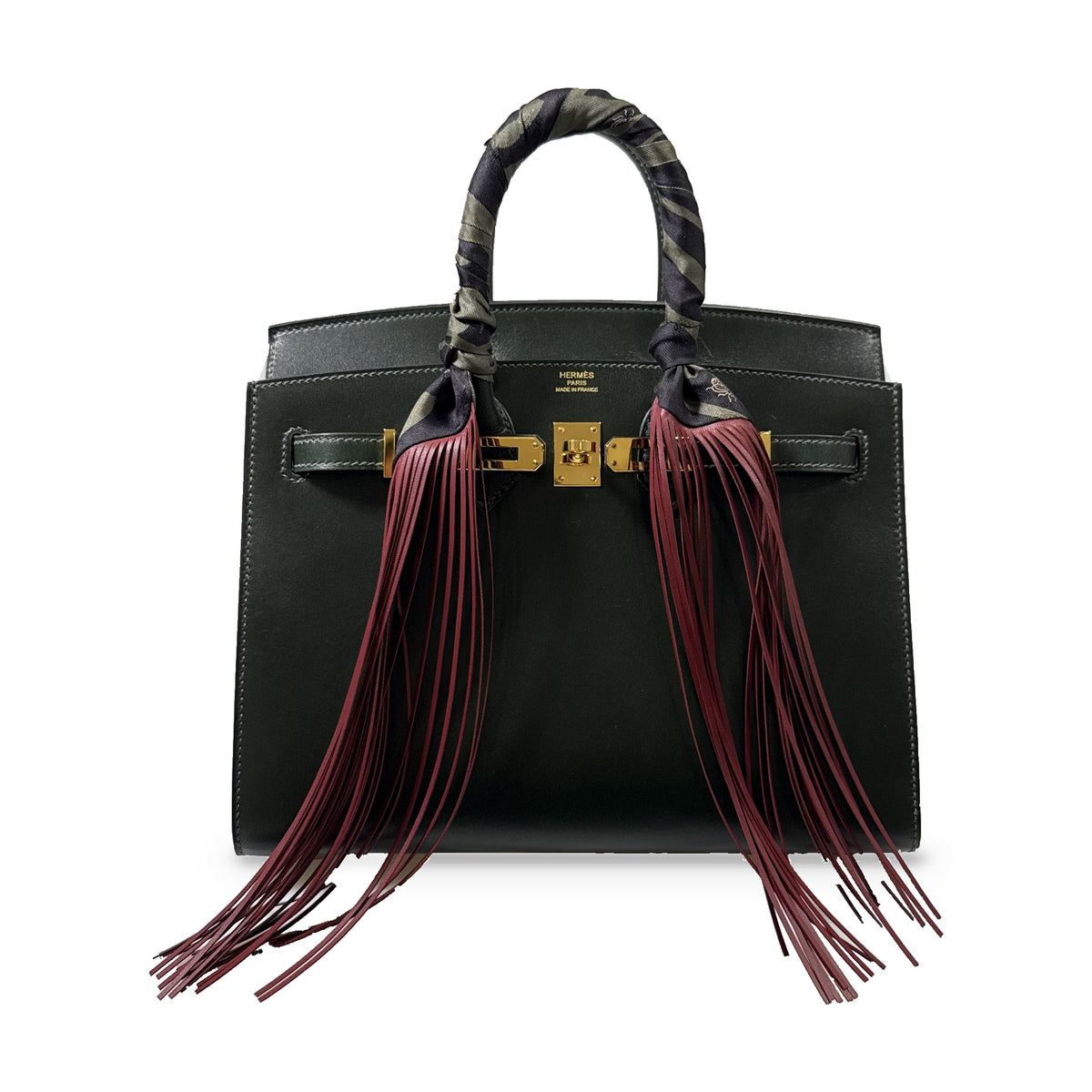 Hermès Birkin 25 Sellier Vert Foncé Box Calf Gold Hardware, shown with a printed handle wrap and burgundy leather fringe, sold separately.