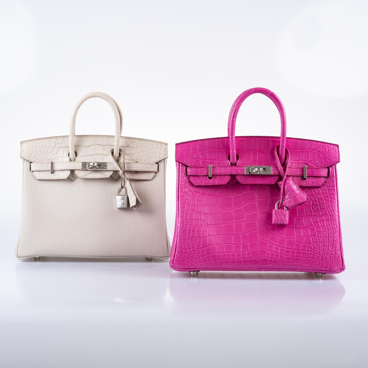 Hermès Birkin 25 Touch Béton at left, beside a pink exotic-leather Birkin, the pink handbag sold separately.